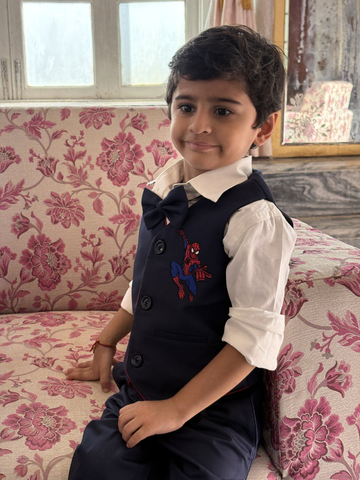 Boy wearing FunnyBones Blue Waistcoat with Superhero Patch – navy waistcoat with superhero patch, shirt and bow tie