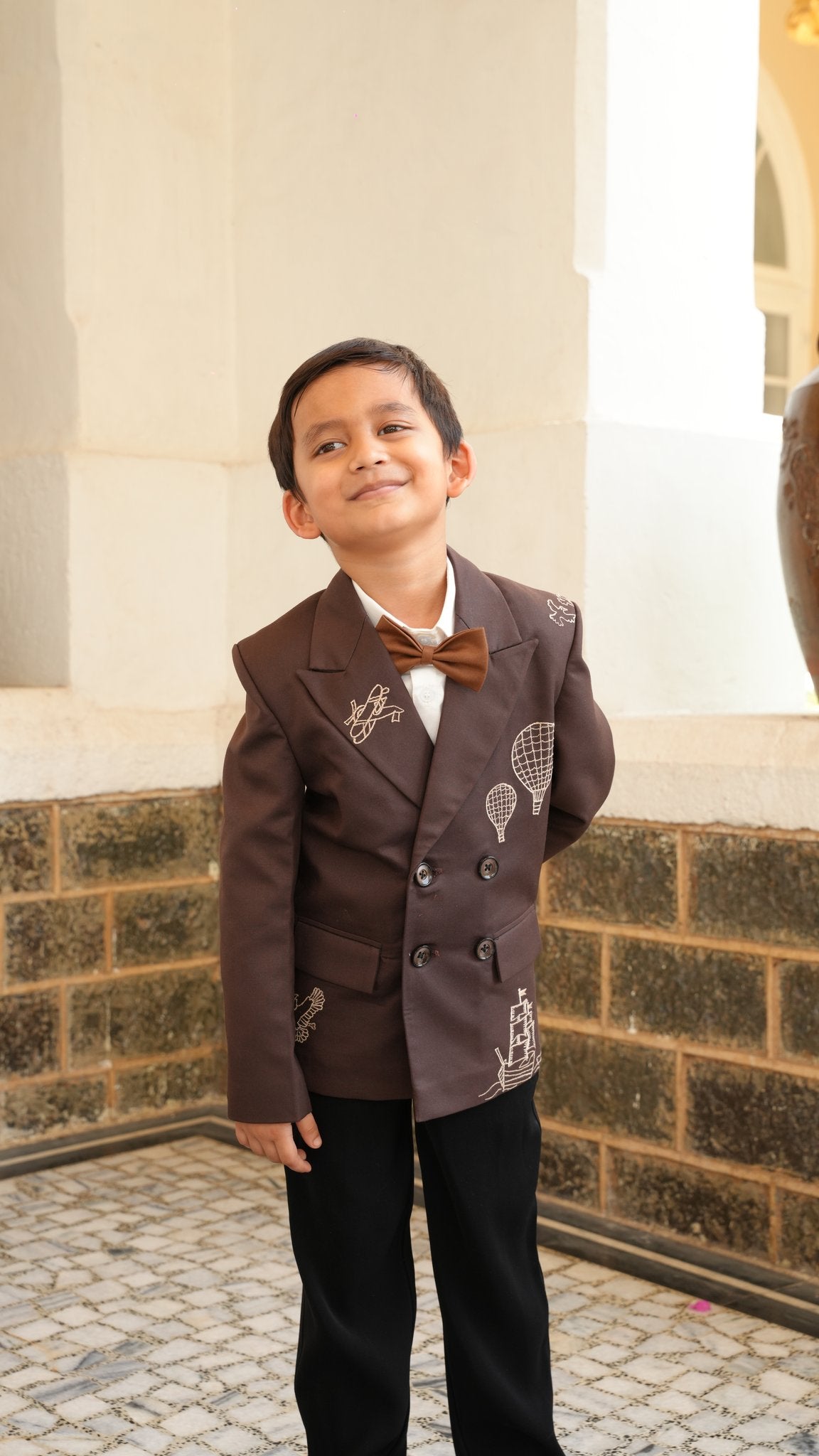Boy wearing FunnyBones Brown Double-Breasted Blazer with Voyage Embroidery – brown double-breasted blazer with hot-air balloon and ship embroidery