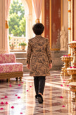 Back view of the camel brown achkan showing black floral embroidery across the back and sleeves