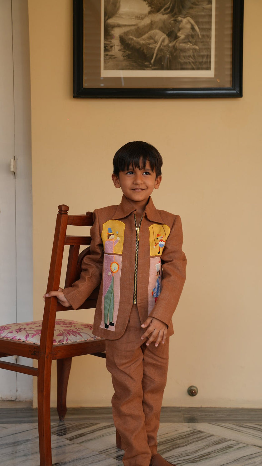 Boy wearing FunnyBones Circus Appliqué Zip Jacket – brown linen zip jacket with circus applique panels