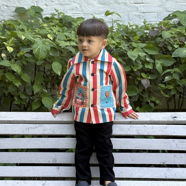 Boy wearing FunnyBones Circus Stripe Shirt Jacket – red, blue and cream striped shacket with circus patches