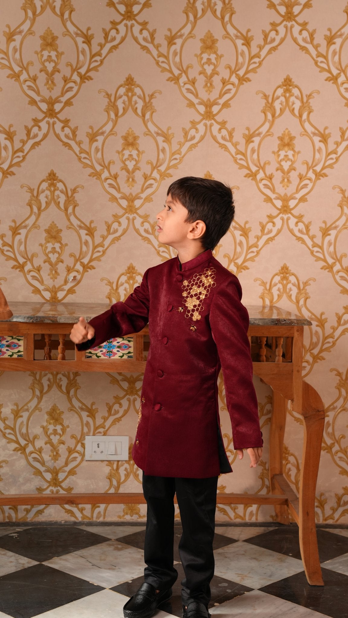 Boy wearing FunnyBones Maroon Achkan with Honeycomb Embroidery – maroon achkan with gold zari honeycomb and bees
