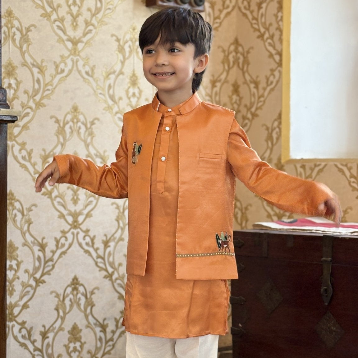 Boy wearing FunnyBones Orange Monkey Nehru Jacket – orange Nehru jacket with monkey and vine embroidery