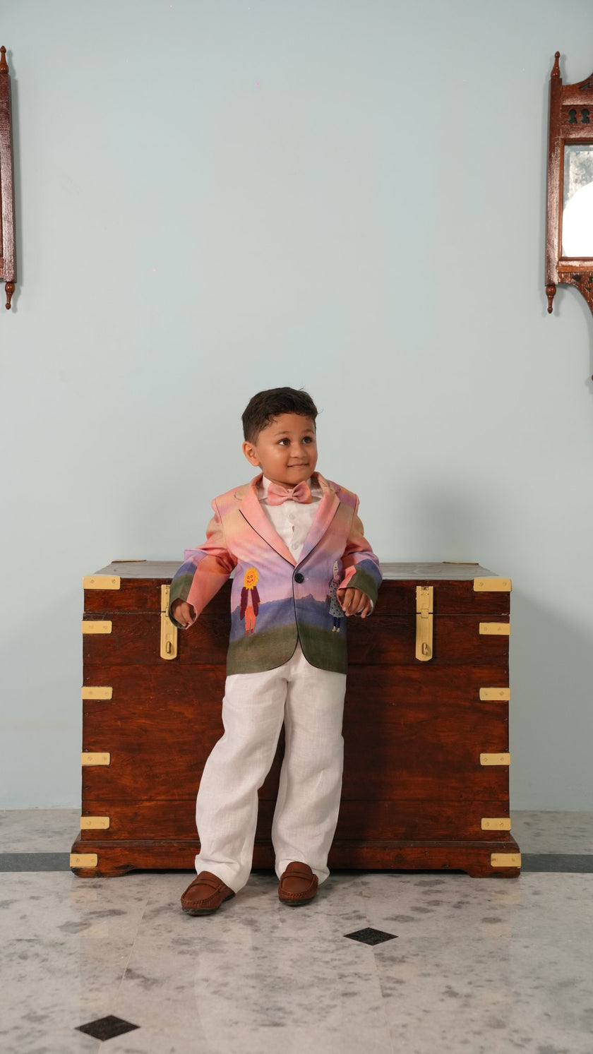 Boy wearing FunnyBones Sunset Storybook Blazer – ombré pink and lilac linen blazer with white pants